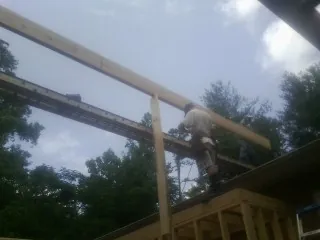 Carpenter setting a ridge beam over a new addition frame — Ice Dam Removal by Roofing Brothers in Charlemont