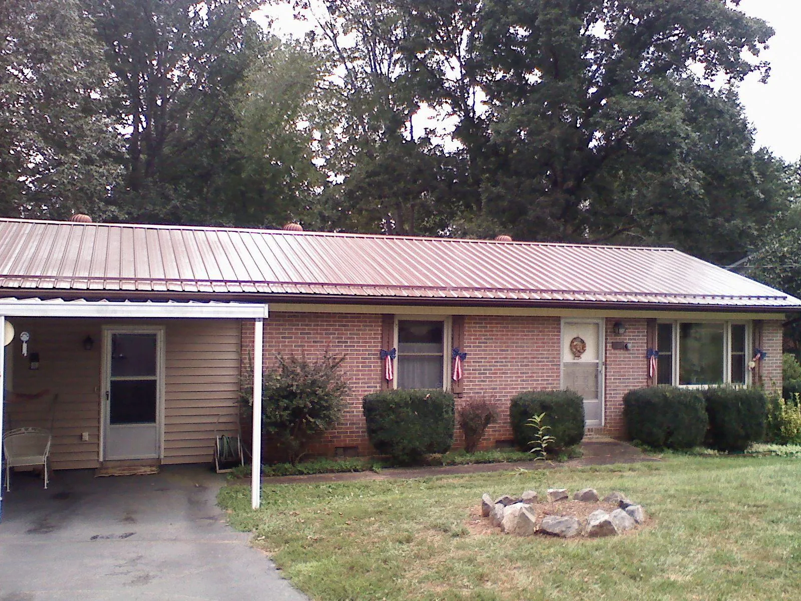 Bronze metal roof and carport on a brick ranch home — Roof Repair work by our crew in Charlemont